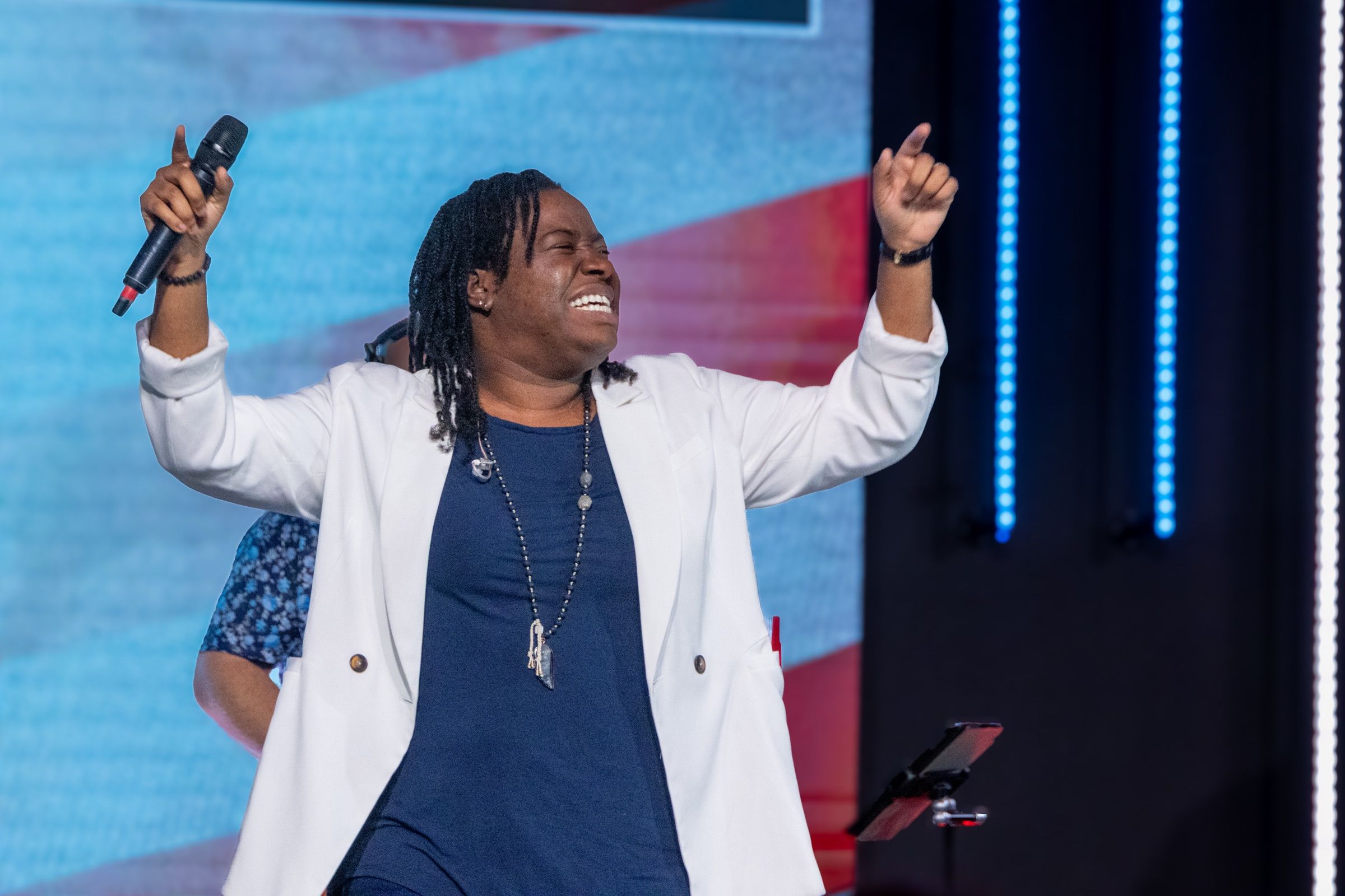 A worship leader singing with joy on stage